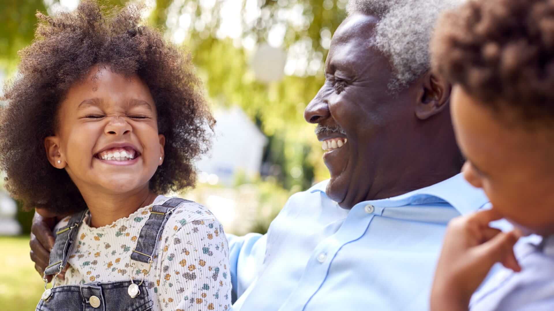 private family cover across generations, older man laughing with grandchildren