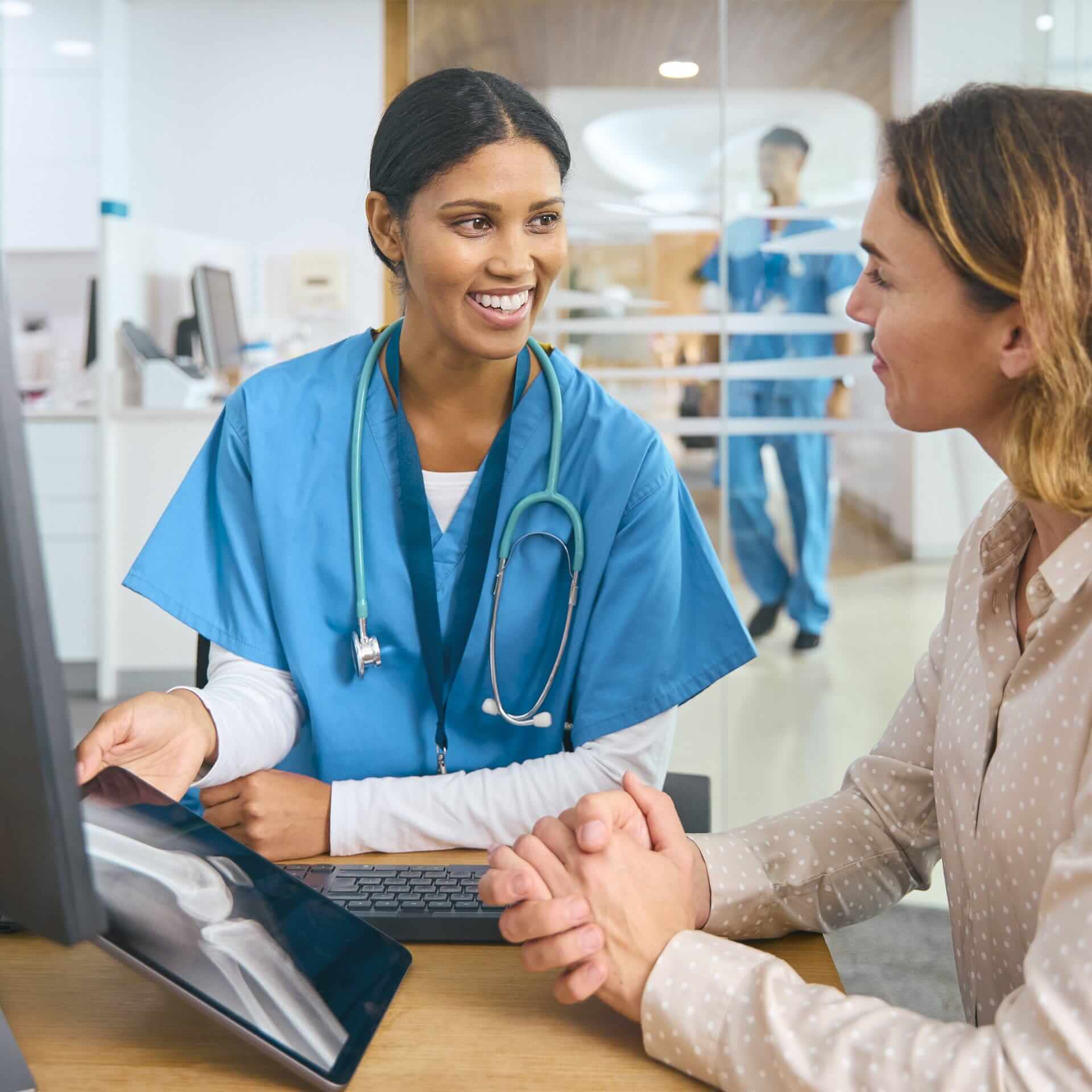 Healthcare professional discussing information on a tablet with a patient